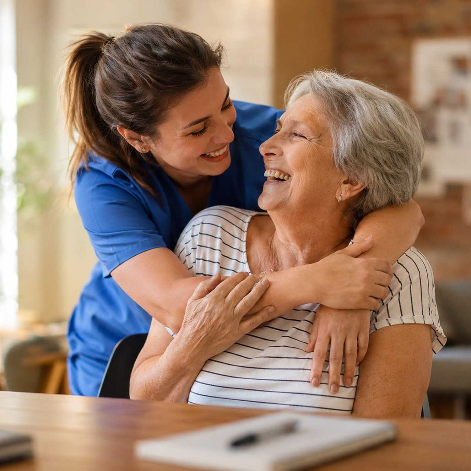 Image of an older woman receiving a hug from a caregiver.