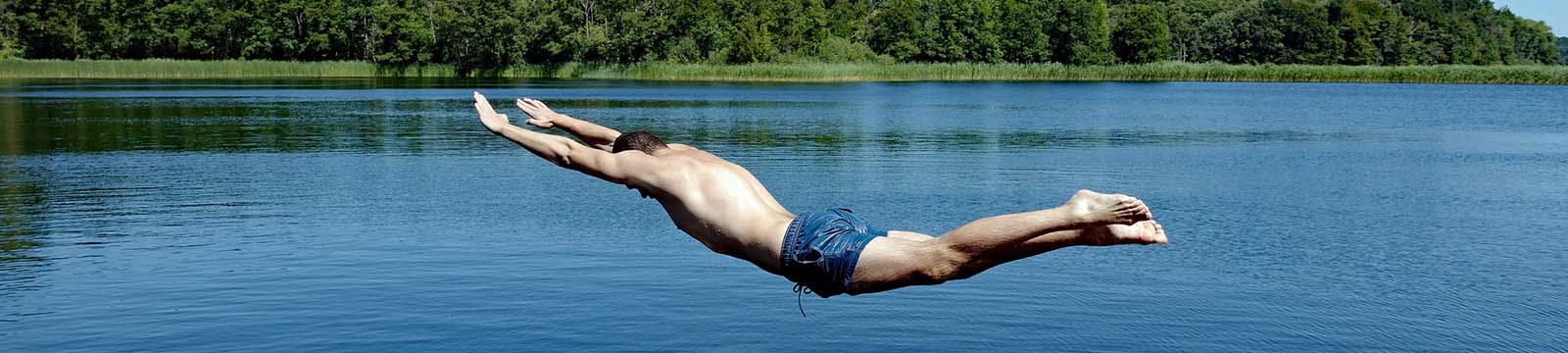 Photo of a man diving into a lake.